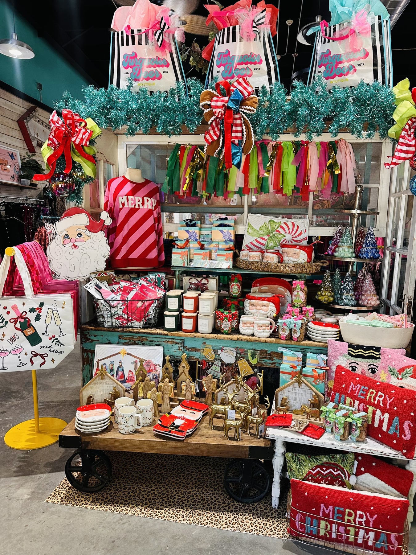 front table display. chritstmas tops, candles, mugs, pillows, totes
